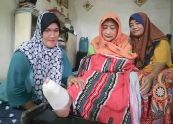 NORSHAMSIAH Saad (tengah) dijaga oleh Wan Saripah Wan Ismail (kanan) di Kampung Tok Dor, Ajil, Hulu Terengganu. – UTUSAN/NOOR HAYATI MAMAT