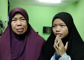 SARIMAH Ahmad (kiri) bersama anak perempuannya, Nur Izzati ketika ditemui pemberita di Parit Tok Ngah, Tanjung Piandang di Parit Buntar hari ini. - UTUSAN/WAT KAMAL ABAS