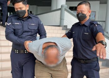 TERTUDUH yang juga seorang pesara kerajaan diiring keluar anggota polis selepas mengaku tidak bersalah di Mahkamah Sesyen, Ayer Keroh, Melaka atas pertuduhan menghantar mesej secara seksual terhadap anak tirinya.
