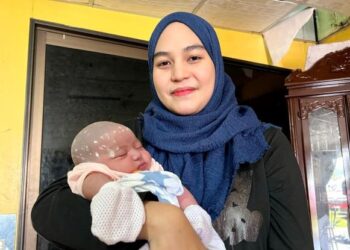 NURUL Atikah Mustafa memangku bayi perempuannya yang lahir tanpa disedari berada dalam kandungannya sejak sembilan bulan lalu 
di Bintong, Kangar, Perlis. – UTUSAN/MOHD. HAFIZ ABD. MUTALIB