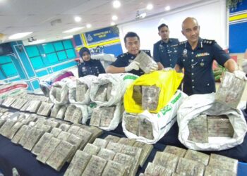 SOFFIAN SANTONG (kanan) menunjukkan ketulan mampat ganja yang dirampas hasil serbuan ke atas satu sindiket pengedaran dadah dalam sidang akhbar di IPD TL, George Town, Pulau Pinang hari ini.