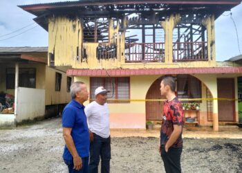 MOHD Zulffi Ramli (kanan)  semasa menerima kunjungan  Timbalan Ketua UMNO Bahagian Tumpat, Wan Hanapi Wan Yakob selepas rumahnya terbakar di Kampung Kepulau, Tumpat, Kelantan hari ini.-UTUSAN/ROHANA ISMAIL.
