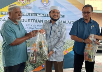 DR. Nik Muhammad Zawawi Salleh (tengah) menyampaikan agihan buah nanas percuma sumbangan LPNM kepada kumpulan sasaran di Pasir Puteh, Kelantan, hari ini.-UTUSAN/TOREK SULONG