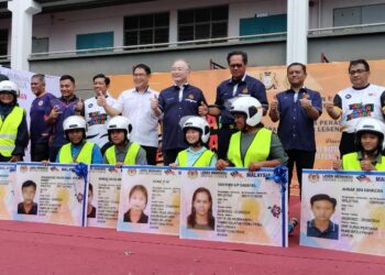 WEE KA SIONG (berdiri, empat dari kanan) bersama-sama sebahagian daripada penerima Bantuan Lesen Keluarga Malaysia (BLKM) yang diserahkan di SMK Suria Perdana di Parit Raja, Batu Pahat.