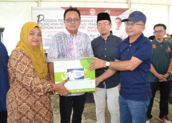 MOHD. Salim Mohd. Sharif (dua dari kiri) menyampaikan sumbangan kepada penerima pada Program Pekebun Kecil Makmur dan  Projek Bersepadu Pembangunan Ekonomi Kampung (Prospek) Jempol di Kampung Serting Ilir Jempol hari ini.-UTUSAN/ZAKKINA WATI AHMAD TARMIZI.