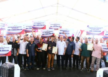 ISMAIL Sabri Yaakob (tengah) bergambar bersama penerima Bantuan Musim Tengkujuh Risda pada Majlis Pekebun Kecil Makmur Keluarga Malaysia di Padang Awam Kampung Batu Papan di Bera, Pahang. - UTUSAN/SHAIKH AHMAD RAZIF