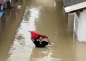 SEORANG penduduk Kampung Padang Jawa sedang meredah banjir hujung Disember tahun lalu.
-ABDUL RAZAK IDRIS