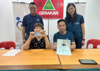 CHIN MEW YOONG (kiri) menunjukkan MyKad yang diperoleh dengan bantuan Pengerusi Gerakan Pulau Pinang, Oh Tong Keong (kanan) di Ibu Pejabat Gerakan Pulau Pinang, Jalan Macalister, George Town hari ini.