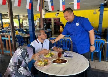 ABDUL HAKIM Abdul Wahid (kanan) menyantuni pengundi sambil makan tengah hari di sebuah restoran di Simpang Solok Duku, Masjid Tanah, Melaka. - UTUSAN/MUHAMMAD SHAHIZAM TAZALI