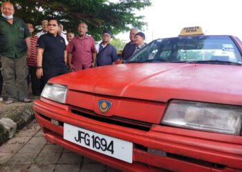 ZAHARI Kechik (dua kiri) semasa turun padang menyantuni pemandu kereta sewa di Jeli, Kelantan hari ini.-UTUSAN/YATIMIN ABDULLAH