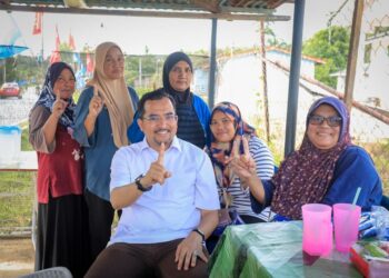 ASYRAF Wajdi Dusuki (depan) bersama penduduk ketika walkabout di Kampung Padang Stang, Gerik. - UTUSAN