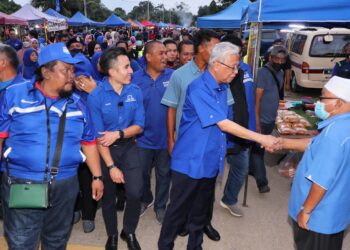 ISMAIL SABRI Yaakob (dua dari kanan) diiringi calon BN Parlimen Alor Gajah, Shahril Sufian Hamdan (dua dari kiri) beramah mesra bersama peniaga ketika mengunjungi Pasar Malam Durian Tunggal, Alor Gajah, Melaka. - UTUSAN/RASUL AZLI SAMAD