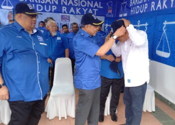 AHMAD ZAHID Hamidi memakaikan topi BN kepada Ketua UMNO Bahagian Tangga Batu, Datuk Seri Mohamad Ali Mohamad sebagai simbolik merasmikan BN Comm Parlimen Tangga Batu dan melancarkan PDM Bukit Terendak Sungai Udang, Melaka. - UTUSAN/AMRAN MULUP