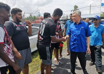 AHMAD Zahid Hamidi bersalam dengan peserta pertandingan futsal di Bagan Datuk hari ini. - UTUSAN/AIN SAFRE BIDIN