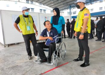 MOHAMAD SHAFIQ 
 Hassan tetap hadir menunaikan tanggungjawab sebagai pengundi awal PRU15 di Dewan Mutiara, IPK Pulau Pinang di George Town, hari ini meskipun dalam keadaan berkerusi roda dan tangan beranduh akibat kemalangan jalan raya.