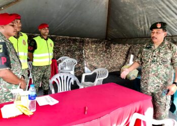 ABU Hasan Assha'ari Kamis@Shaffie (kanan) berbual dengan petugas untuk pengundian awal di Kem Desa Pahlawan, Kok Lanas, Kota Bharu hari ini. - UTUSAN/ROSLIZA MOHAMED