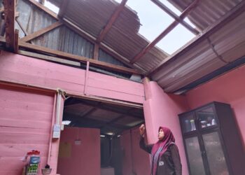NUR Zahira Budin menunjukkan bahagian rumahnya yang rosak dalam kejadian ribut di Felda Pasir Besar, Gemas, Tampin hari ini. - UTUSAN/NOR AINNA HAMZAH