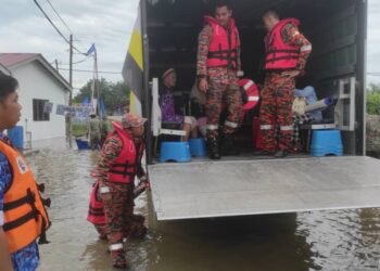 PASUKAN penyelamat membantu mangsa banjir di Changkat Jong, Teluk Intan hari ini. - UTUSAN