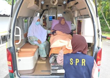FATIMAH Ismail mengundi dalam ambulans di pusat pembuangan undi di SK Rusila, Marang, Terengganu, hari ini. - UTUSAN/PUTRA HAIRRY ROSLI