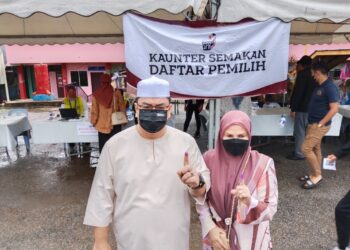 SULAIMAN Md. Ali dan isteri menunjukkan jari telunjuk selepas selesai mengundi di SK Durian Daun, Masjid Tanah, Melaka. - UTUSAN/MUHAMMAD SHAHIZAM TAZALI