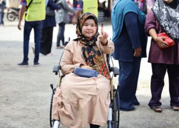 NOR Mahirah Aliya Ibrahim terpaksa berkerusi roda semasa mengundi di Sekolah Kebangsaan Padang Mokan, Ketereh, Kota Bharu, Kelantan.UTUSAN/KAMARUL BISMI KAMARUZAMAN