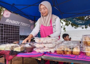 NUR SYUHADA Md. Saleh menambah bekalan pastri selepas gerainya di Pantai Telok Gong di Masjid Tanah, Melaka mencatatkan peningkatan jualan pada hari pengundian. - UTUSAN/
MUHAMMAD SHAHIZAM TAZALI