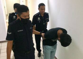 MOHAMAD Hadi Wahab (depan, kanan) dibawa keluar dari Mahkamah Majistret Kuala Terengganu, hari ini. - UTUSAN/TENGKU DANISH BAHRI TENGKU YUSOFF