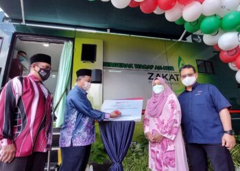 DR. ROSLAN Ahmad menurunkan tandatangan pada plak perasmian ketika majlis pelancaran Klinik Bergerak Wakaf An-Nur Zakat Pulau Pinang di Bandar Perda, Pulau Pinang hari ini.