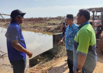 ZULKAFPERI Hanapi (berkopiah) meninjau keadaan ban yang sedang dibaik pulih di pesisir pantai Kampung Sungai Kajang, Tanjong Karang, Kuala Selangor, Selangor. -UTUSAN/ ISKANDAR SHAH MOHAMED