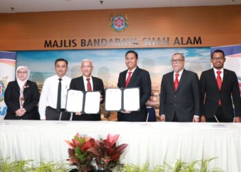MOHD. Rashidi (tiga dari kanan) dan Azmee (tiga dari kiri) menunjukkan MoU yang dimeterai bagi mewujudkan kawasan selamat untuk kenderaan menerusi laluan khas sewaktu banjir di Wisma MBSA, Shah Alam, Selangor hari ini.
-ABDUL RAZAK IDRIS
