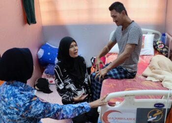 ANGGOTA APM Kuala Selangor membantu Khalijah menguruskan Mohd. Radzuan 
di PPS Dewan MPKS Bestari Jaya, Bestari Jaya, Kuala Selangor, Selangor.