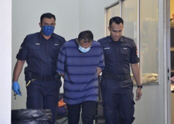 C. Stephen Raj (tengah) diiringi anggota polis tiba di Mahkamah Majistret Kajang bagi pertuduhan membunuh anak tiri perempuan berusia 11 tahun.