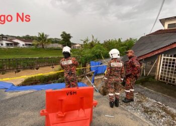 ANGGOTA bomba memeriksa sebuah rumah teres yang runtuh di bahagian hadapan dalam kejadian tanah runtuh di Taman Sri Anggerik, Rantau, Seremban petang tadi.-GAMBAR/IHSAN BOMBA.