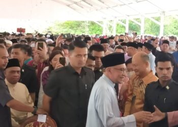 ANWAR Ibrahim disambut bersalaman dengan orang ramai pada program Kenduri Rakyat bersama Perdana Menteri Malaysia di Taman Jati di Ipoh hari ini. - UTUSAN/ASLIZA MUSA