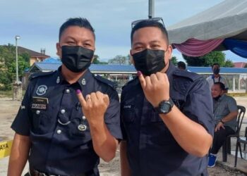 DUA anggota polis selesai mengundi awal di Ibu Pejabat Polis Daerah (IPD) Rompin di Rompin, Pahang. -UTUSAN/SALEHUDIN MAT RASAD