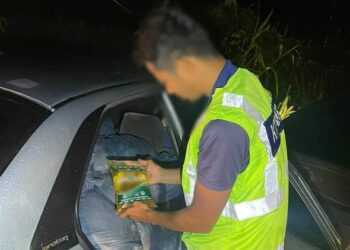 ANGGOTA penguat kuasa KPDN memeriksa minyak masak peket yang dirampas dalam serbuan di Kampung Teliar, Bunut Susu, Pasir Mas, Kelantan. - UTUSAN/IHSAN KPDN