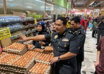MOHD. Khairi Jamaludin (tengah) membuat pemeriksaan terhadap bekalan ayam, telur dan minyak masak paket dekat sebuah pasar raya di Gombak, Selangor, hari ini.