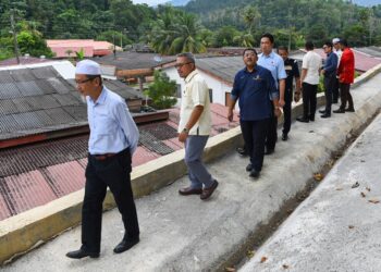 TEO Kok Seong (empat dari kiri) dan Ir. Wan Hasnan Wan Musa (dua dari kiri) melihat projek membina dan membaiki cerun runtuh di Rumah Rakyat Panchor, Seremban yang telah disiapkan pada 17 November lalu.