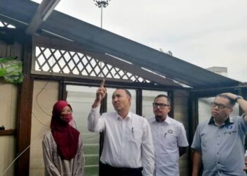 MOHD. JAFNI MD. SHUKOR (dua dari kiri) melawat sebuah rumah di Kampung Datuk Sulaiman Menteri, di sini yang bumbungnya diterbangkan dalam kejadian ribut minggu lalu.
