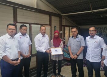 JUNAIDAH JAMIL menerima sumbangan yang disampaikan Mohd. Jafni dan Mohd. Hairi yang melawat rumahnya di Kampung Datuk Sulaiman Menteri, Johor Bahru.