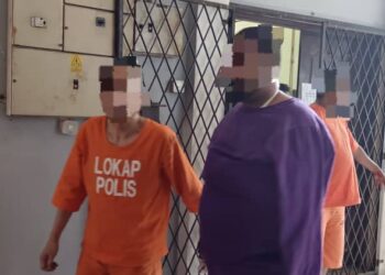 SUSPEK kes samun kedai emas menggunakan pistol mainan (kanan) dibawa ke Mahkamah Majistret Ipoh bagi mendapatkan perintah tahanan reman hari ini. - UTUSAN