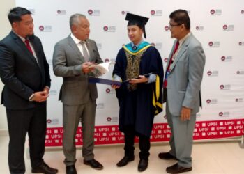 IZRAN Mohamad Saaban (dua dari kanan) menunjukkan buku Ringkasan Ilmu Tajwid Al-Quran yang dihasilkannya kepada Md Amin Md. Taff sempena majlis Istiadat Konvokesyen UPSI ke-24 di Tanjung Malim hari ini. - UTUSAN/IHSAN UPSI