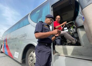 HANIF Yusabra Yusuf memeriksa dokumen seorang pemandu bas dalam Operasi Rentas Sempadan yang diadakan di Lebuhraya Seremban-Port Dickson, Negeri Sembilan, hari ini.-UTUSAN/AFIFI HAFIZ MOHD. NOR.