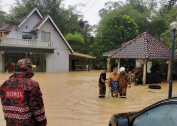 ANGGOTA bomba membawa keluar seorang warga emas yang terperangkap dalam banjir yang berlaku di Kampung Mayor, Pantai, Seremban, petang tadi. GAMBAR/IHSAN BOMBA.