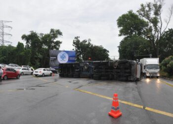 SEBUAH treler terbalik di persimpangan lampu isyarat berhampiran Sekolah Menengah Sains Muzaffar Syah (Mozac), Ayer Keroh, Melaka.