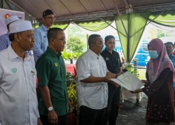 MUHAMMAD Sanusi Md. Nor menyampaikan geran tanah kepada penduduk di sekitar daerah Kubang Pasu dalam Majlis Penutup Jelajah Kedah Sejahtera di Masjid Haji Ismail, Batu 18 di Jitra. -UTUSAN/MOHD RAFIE AZIMI