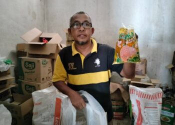 ANUAR OTHMAN menunjukkan baki minyak masak peket yang dijual di kedainya di Pasar Awam, Kluang, Johor.