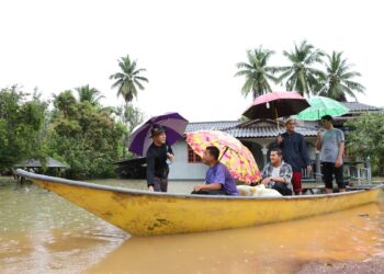 PENDUDUK terpaksa menggunakan perahu untuk keluar mendapatkan barangan keperluan harian selepas kawasan rumah mereka dinaiki air di Rantau Panjang, Kelantan. - UTUSAN/KAMARUL BISMI KAMARUZAMAN