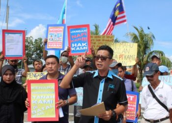 JERRY Jaimeh (dua kanan) bersama Goefle Joseph dan penduduk Skim Peneroka Madai Baturong mengadakan  perhimpunan aman di luar pejabat Urusetia Daerah Kunak.