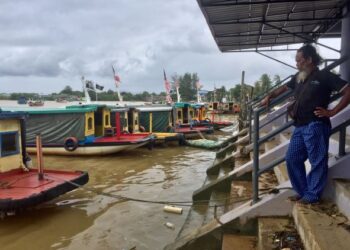 ISMAIL Ali termenung menunggu penumpang bot penambang di Jeti Seberang Takir, Kuala Nerus, Terengganu, semalam. – UTUSAN/TENGKU DANISH BAHRI TENGKU YUSOFF